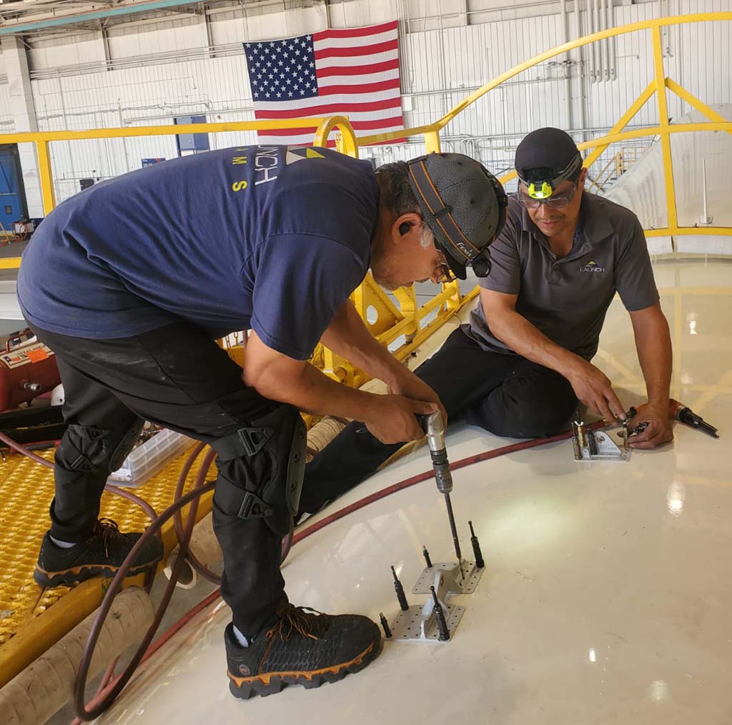 Technicians working on top of aircraft