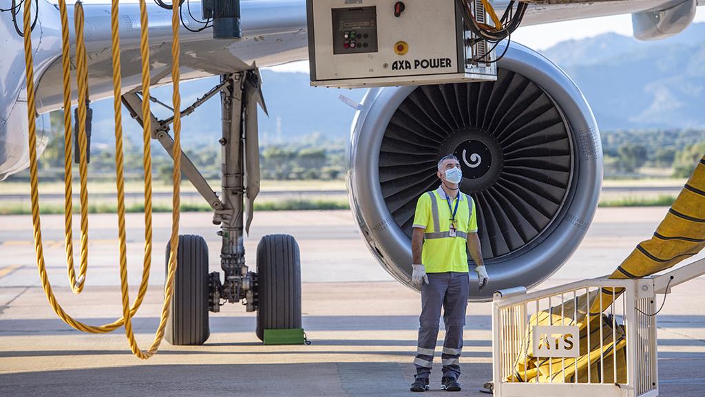 maintenance technician in front of aircraft and engine
